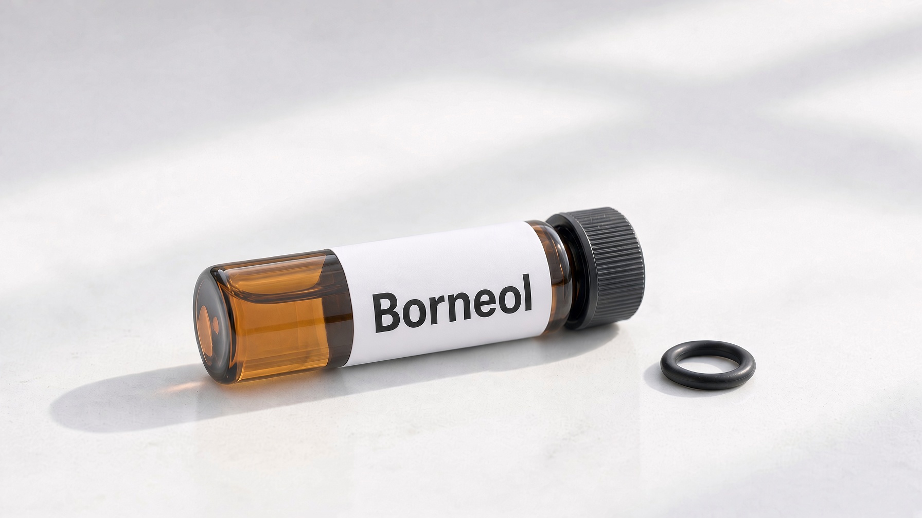 Black rubber O-Ring on frosted glass beside white crystalline borneol powder